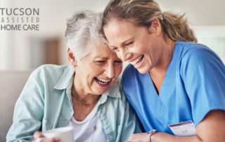 A woman who is providing companion care and her senior client laugh and enjoy their time together.